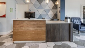 A reception area with a wooden and dark wood counter, a Dell computer, and a coffee machine. - Best Western Plus Executive Suites (Redwood City)