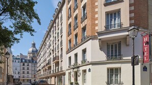 Un hotel d'estil arquitectònic europeu clàssic, amb una cúpula destacada al fons i un rètol vermell que indica el seu nom.