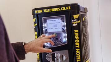 A self-service kiosk with a screen displaying a message about a passenger selection and total charge.