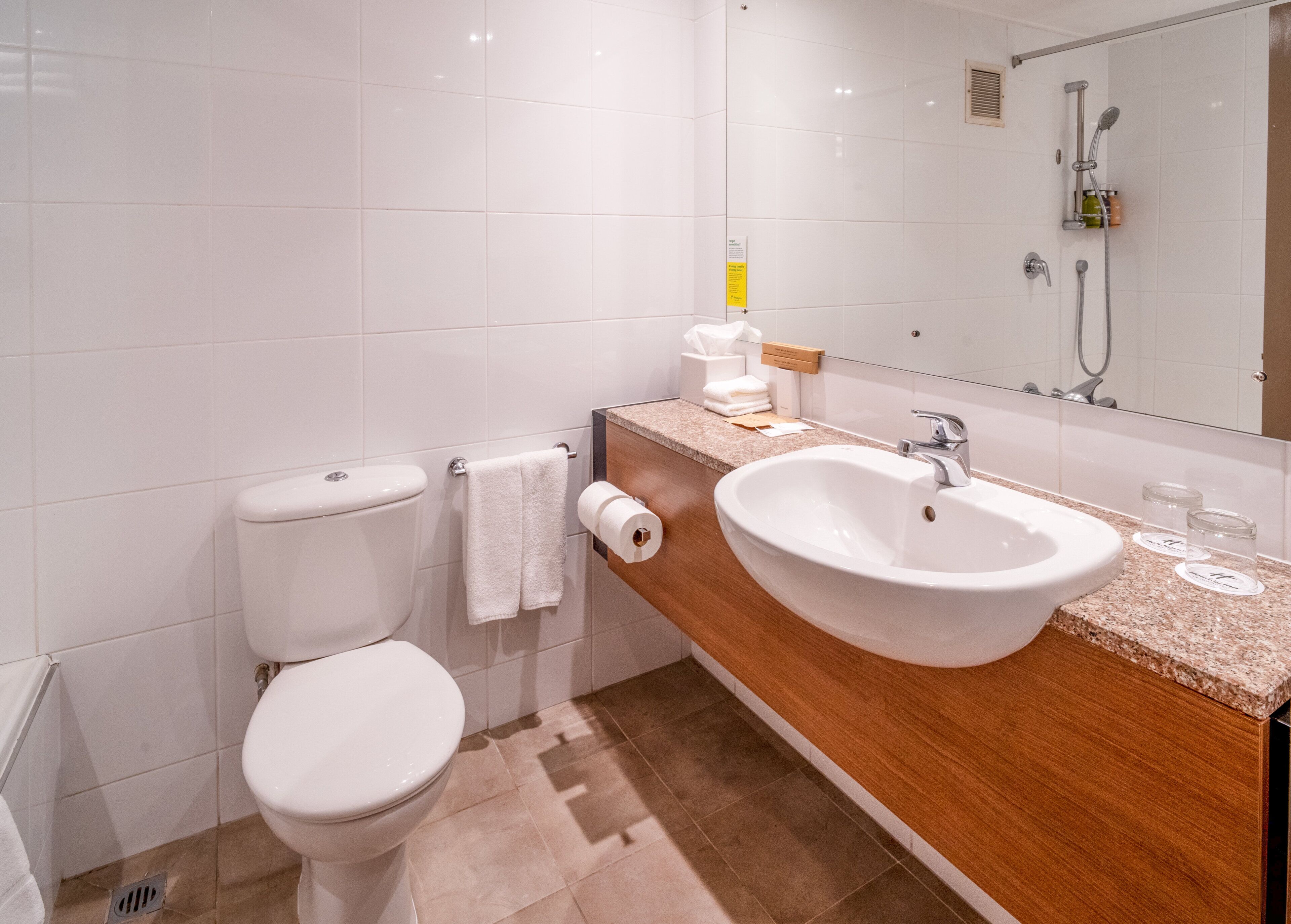 Un baño moderno con inodoro, lavamanos y ducha.