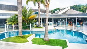 Relax by the pool surrounded by lush greenery and a sleek, modern design.
