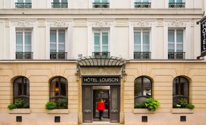Un bâtiment classique dont l’entrée, bien en évidence, porte l’inscription « HÔTEL LOUISON ».