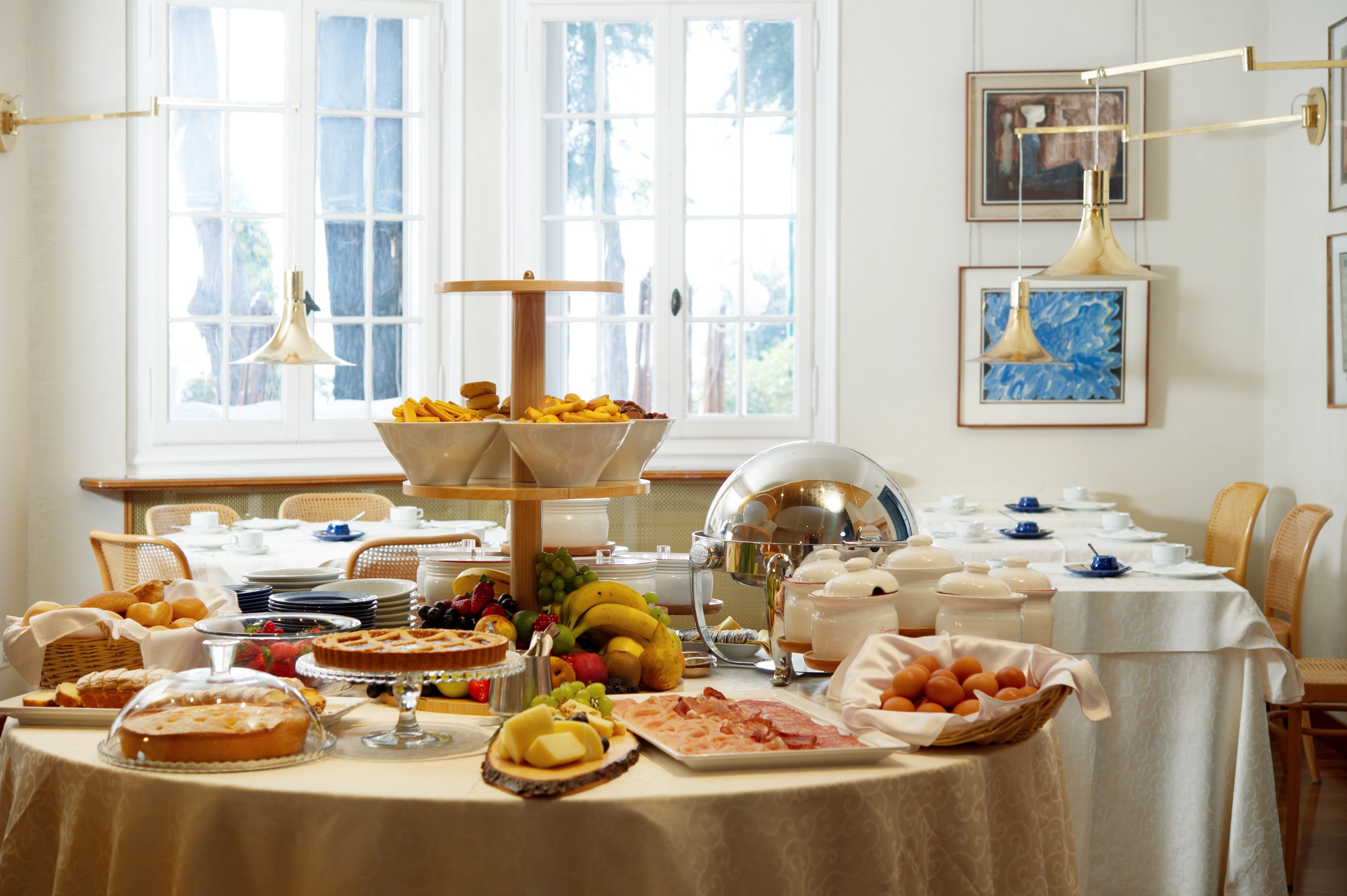 Un buffet de petit-déjeuner proposant une variété d’aliments et un espace repas avec des chaises et des tables.