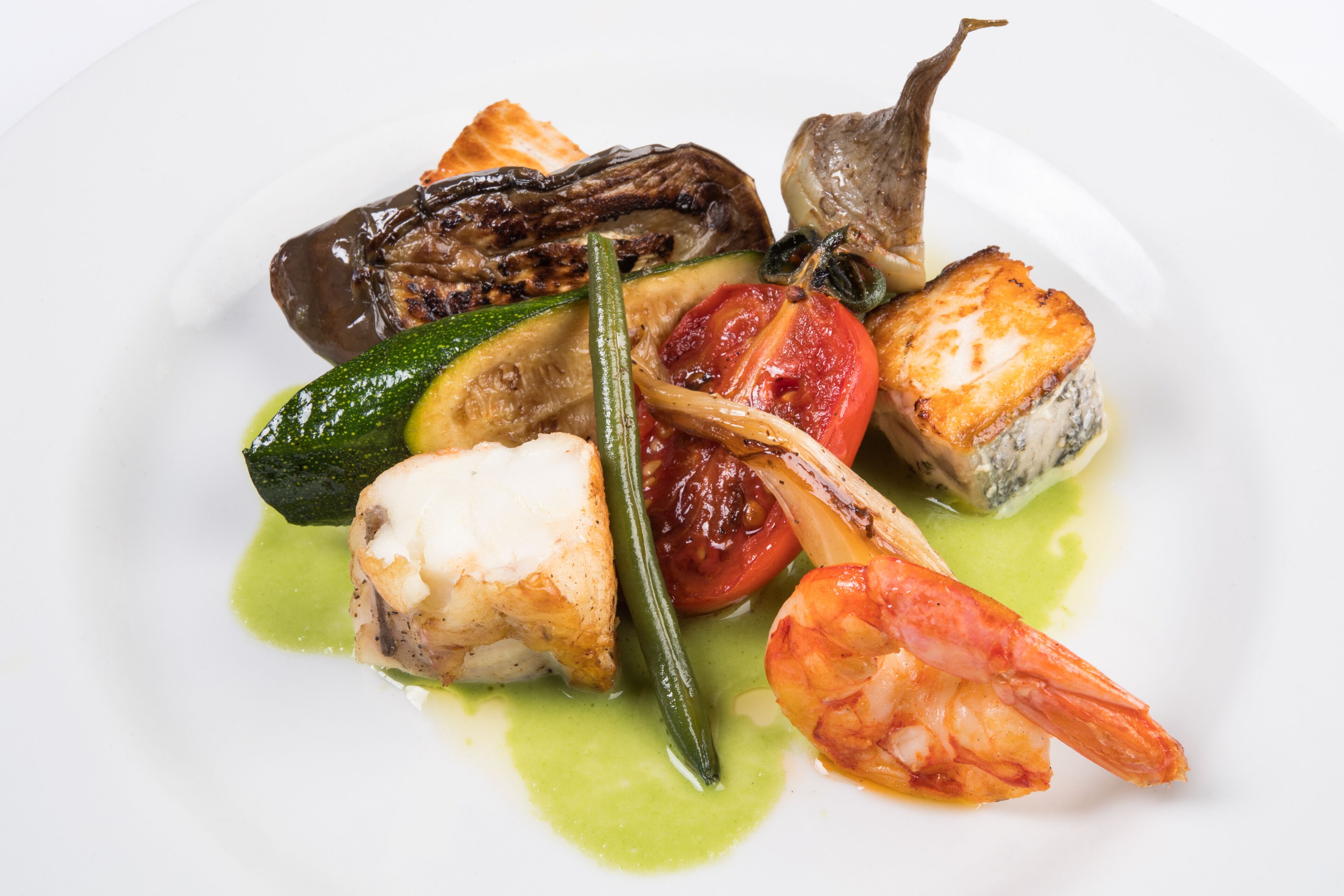 A plate of seafood including shrimp, fish, and vegetables.