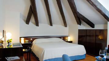 A bedroom with a bed, bedside tables, a desk, a chair, and a wardrobe.