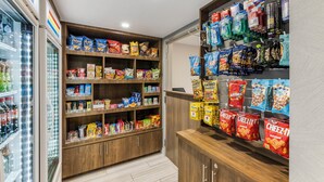 Ein Verkaufsregal mit verschiedenen verpackten Snacks und ein Kühlbereich mit abgefüllten Getränken.