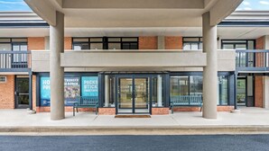 A modern building with a covered entrance, large pillars, and a brick facade. - Red Roof Inn Perryville (Perryville)