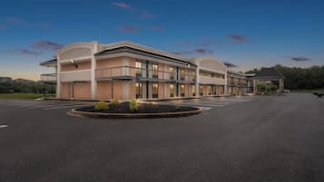 A modern hotel with a spacious parking lot and a covered entrance.