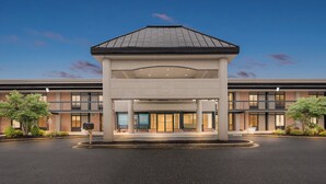 A hotel entrance with a covered waiting area, multiple floors, and a brick facade. - Red Roof Inn Perryville (Perryville)
