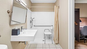 A small bathroom with a sink, mirror, and shower. - Red Roof Inn Perryville (Perryville)