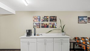 A modern kitchen with white cabinets, a coffee machine, and a potted plant. - Red Roof Inn Perryville (Perryville)