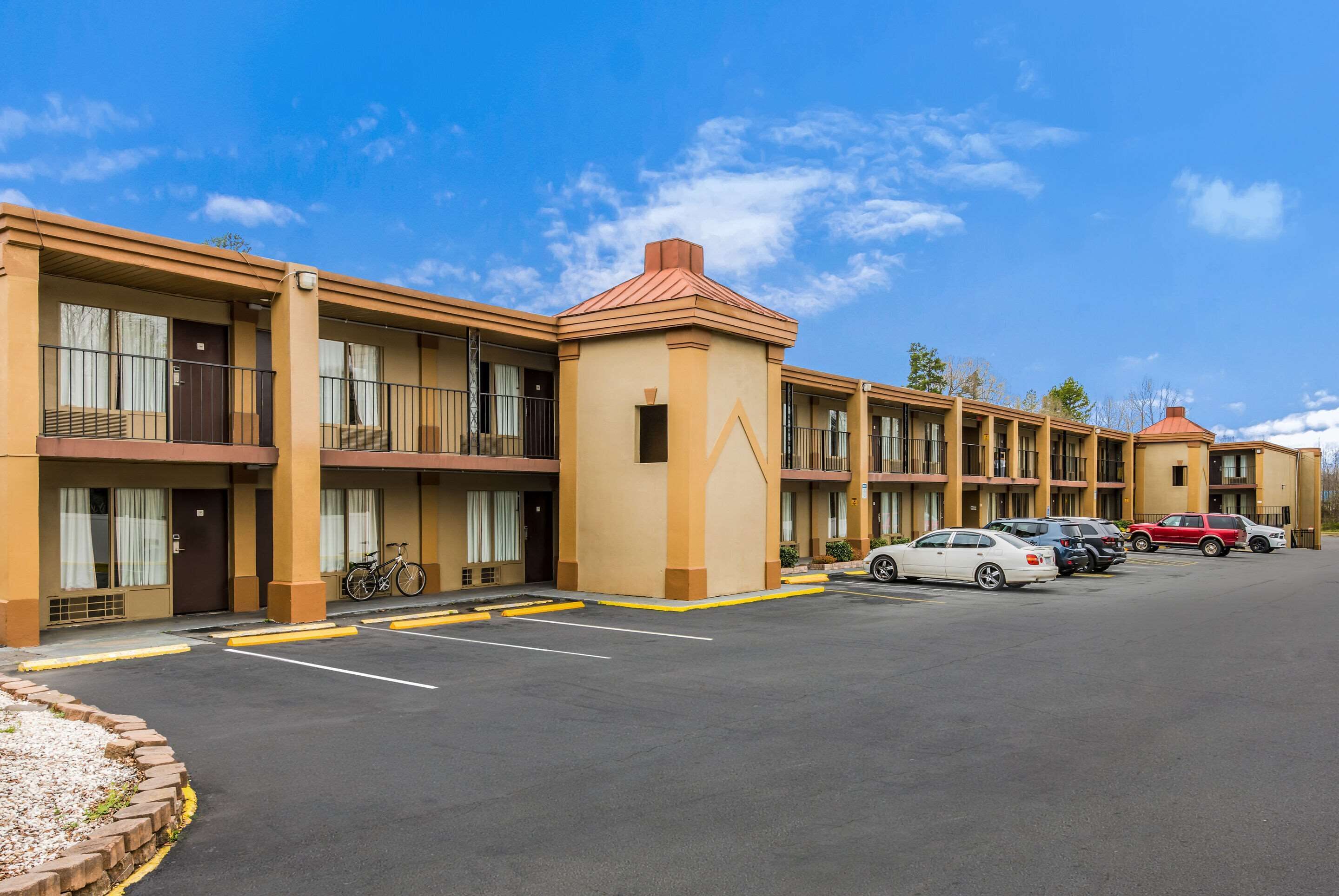 Un motel con varias edificaciones de dos pisos, cada una con balcones y una torre central.