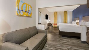 A hotel room with a sofa, a bed, a desk, and a TV. - MainStay Suites Joliet I-80 (Joliet)