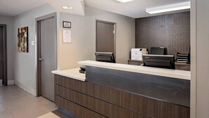 A reception desk with a modern design, a large mirror, and a printer.