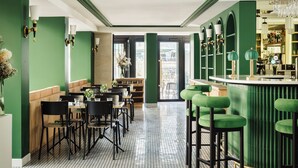 A restaurant with green walls, black chairs, and a bar area with stools. - Hôtel Observatoire Luxembourg (Paris)