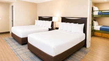 Habitación de hotel con dos camas, una mesita de noche, una lámpara y una cama litera.