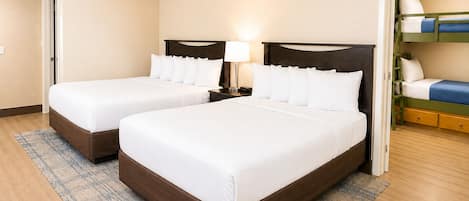 Habitación de hotel con dos camas, una mesita de noche, una lámpara y una cama litera.