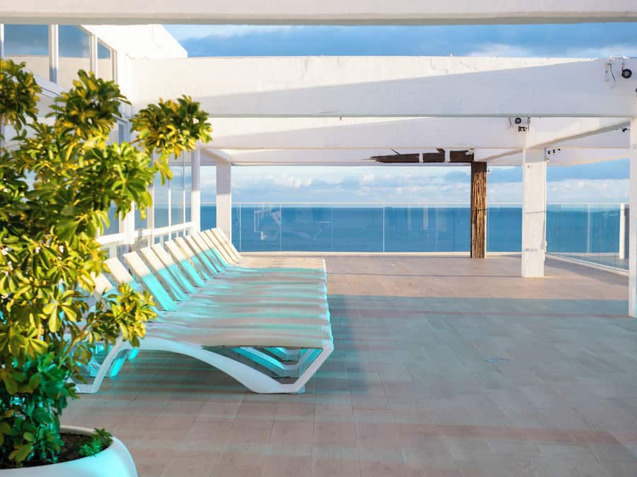 Una piscina techada, una piscina al aire libre, sombrillas