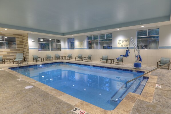 Una piscina techada, sillones reclinables de piscina