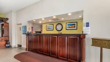 A reception desk with a clock, framed pictures, and a sign for express checkout.