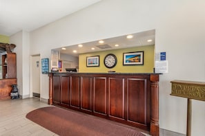 A reception desk with a clock, framed pictures, and a sign for express checkout. - Best Western Kent Narrows Inn (Grasonville)