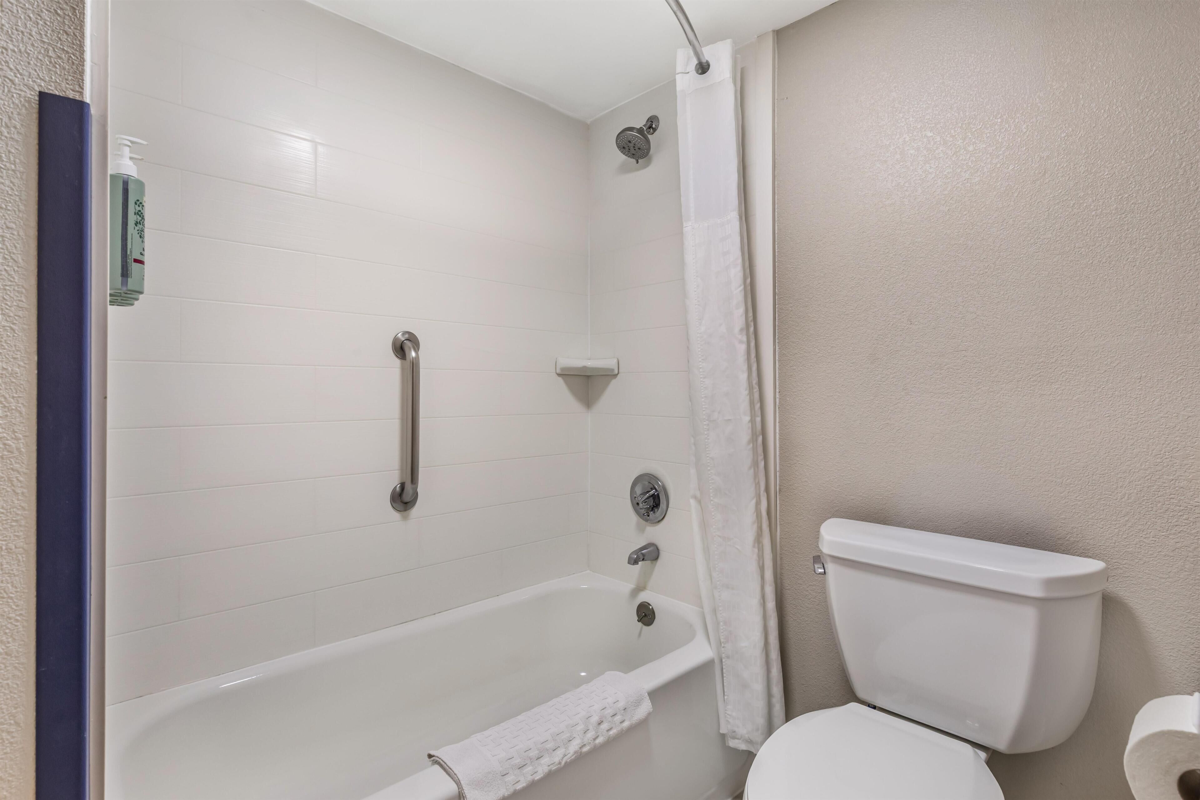 A bathroom with a bathtub, toilet, and shower.