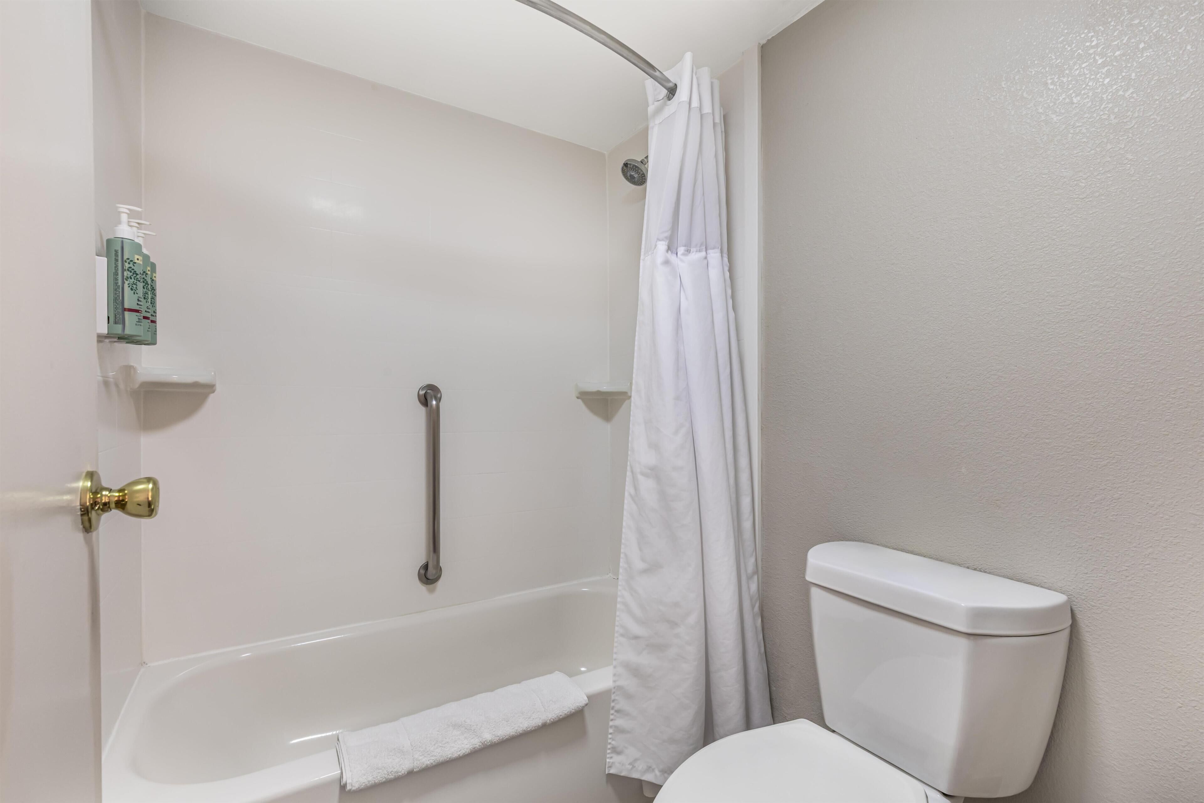 Ein Badezimmer mit Badewanne, Toilette und Duschvorhang.