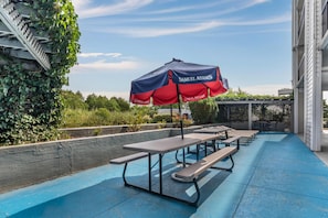 An outdoor patio area with picnic tables and a Samuel Adams branded umbrella. - Best Western Kent Narrows Inn (Grasonville)