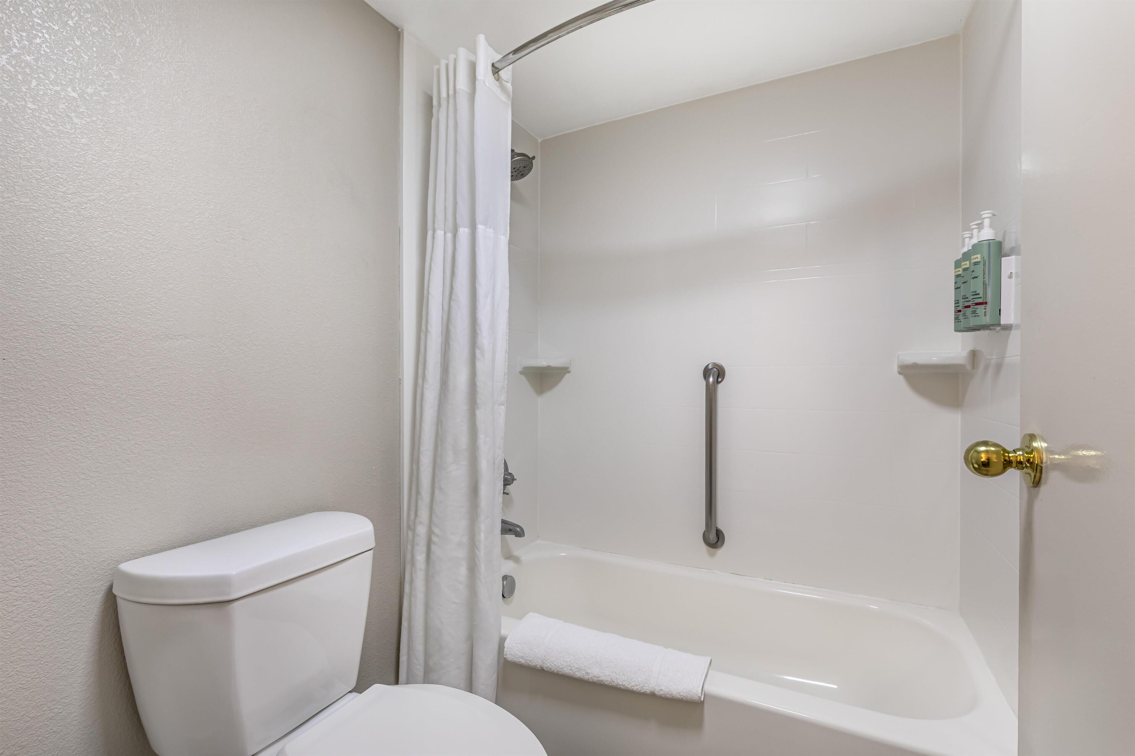 Un baño con inodoro, bañera y cortina de ducha.