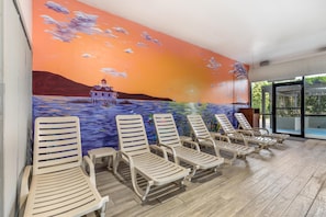 A poolside area with lounge chairs and a mural of a sunset over water. - Best Western Kent Narrows Inn (Grasonville)