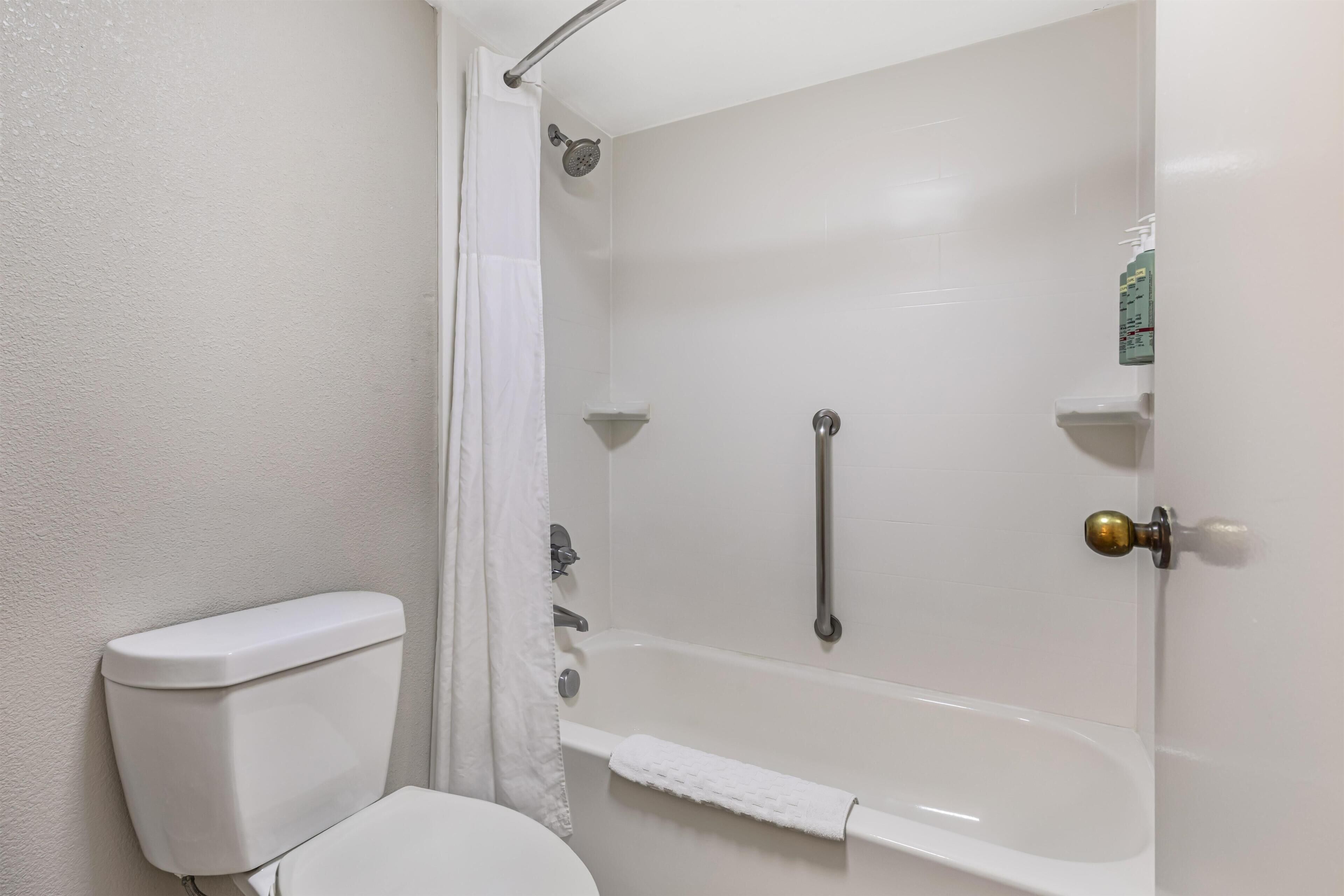 A bathroom with a toilet, a bathtub, and a shower.