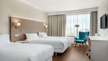 Superior driepersoonskamer | Luxe beddengoed, een minibar, een kluis op de kamer, een bureau