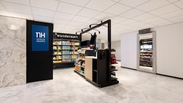 A hotel lobby with a marble floor, a WHWanderMart, and a display for NH Hotels & Resorts.