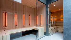 Moderni sauna, jossa on puiset lauteet ja infrapunapaneelit.