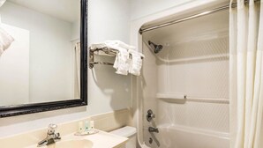 Ein Badezimmer mit Waschbecken, Spiegel, Toilette und Badewanne.