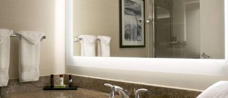 A modern bathroom with a large mirror, a sink, and a vanity.