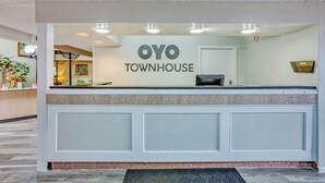 Una mesa de recepción con un cartel que dice 'OYO TOWNHOUSE'.