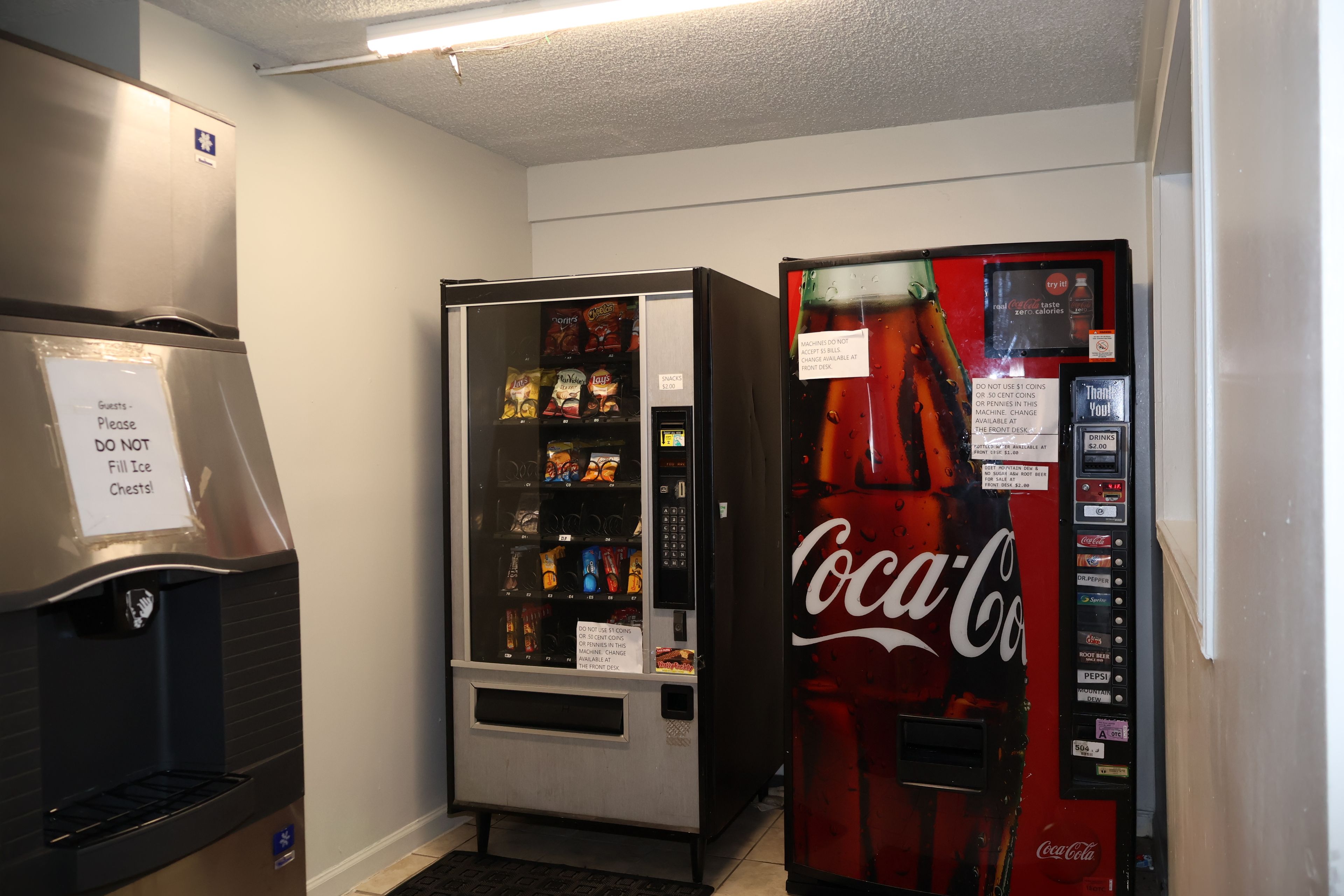 Zona de máquinas expendedoras con aperitivos y una máquina de Coca-Cola.