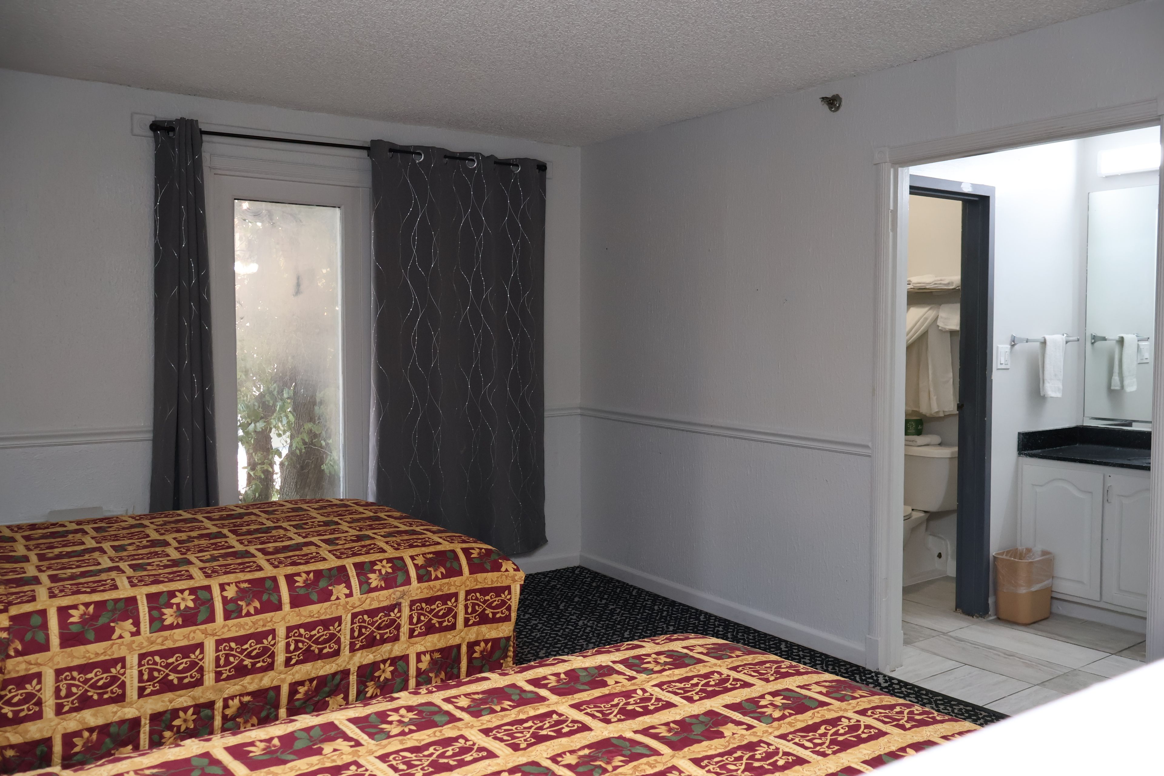 Ein Hotelzimmer mit Bett, Bad und Blick nach draußen.