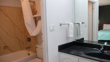 A bathroom with a bathtub, toilet, and a sink with a mirror.