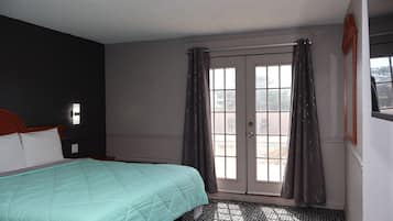 Una camera da letto con un letto, una finestra con tende e una porta.