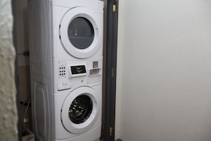 A stacked washer and dryer unit with a digital display. - Garden Cove Hotel Suites (Tulsa)