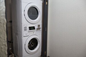Una lavadora y secadora apiladas con pantalla digital.