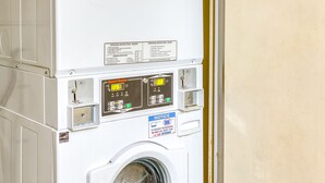Una unidad apilada de lavadora y secadora, con paneles de control e instrucciones de funcionamiento.