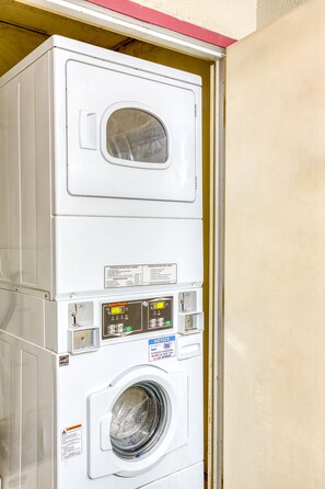 A stacked washer and dryer unit with control panels and operating instructions.