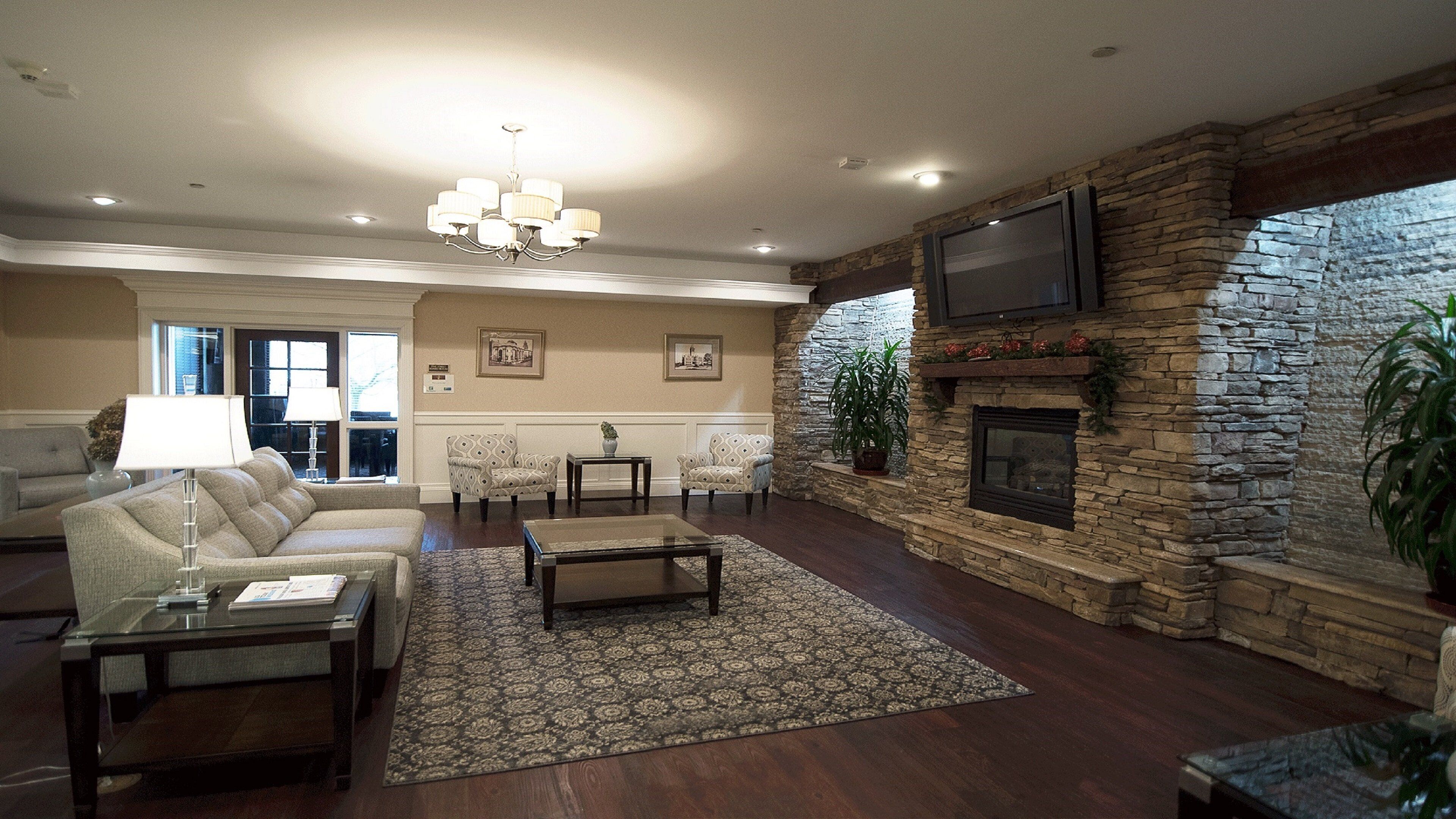 A spacious living room with a fireplace, comfortable seating, and a large television.