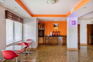 Habitación de hotel con comedor, cocina y baño.
