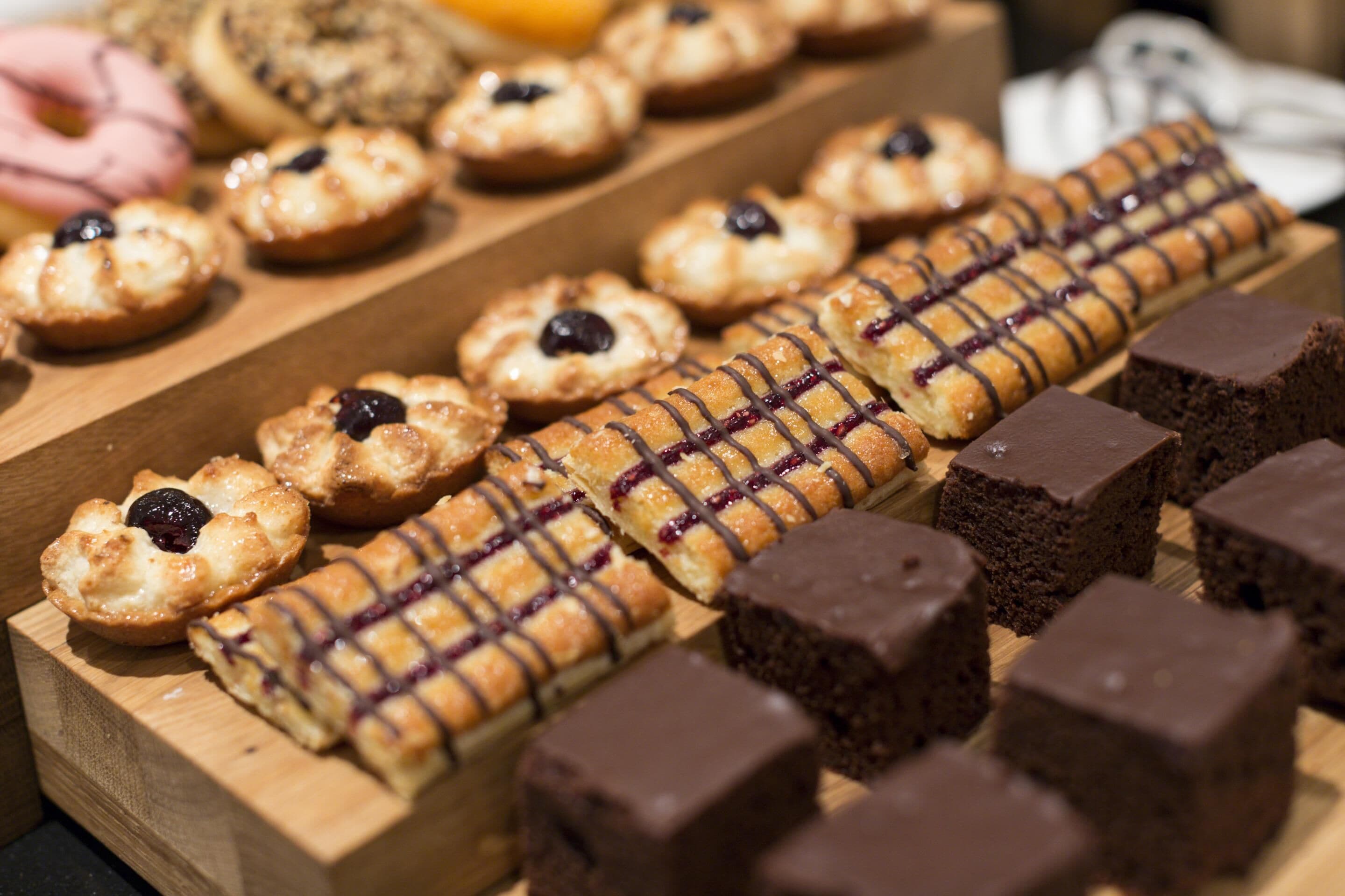 Una selección de pasteles y postres sobre una tabla de madera.