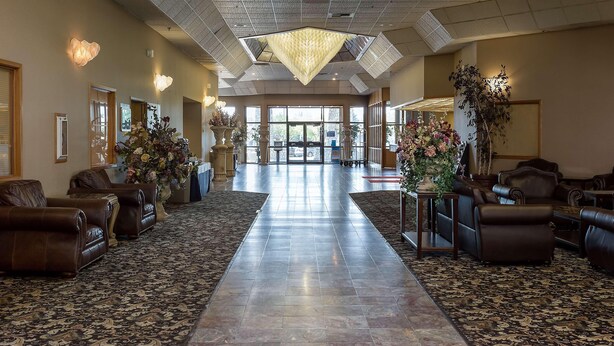 A spacious lobby with leather sofas, a patterned carpet, and a large chandelier. - Shilo Inn Suites Idaho Falls (Idaho Falls)