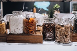 Un bufé con distintos alimentos en frascos de vidrio.